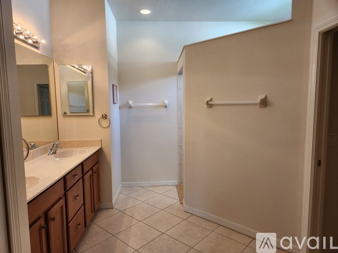 A bathroom with a sink, mirror, and towel rack.