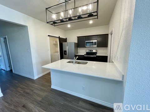 A kitchen with a white countertop and a black fridge.