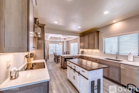 A modern kitchen with wooden cabinets and a marble countertop.