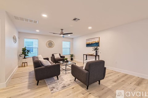 A living room with a ceiling fan and a painting on the wall.