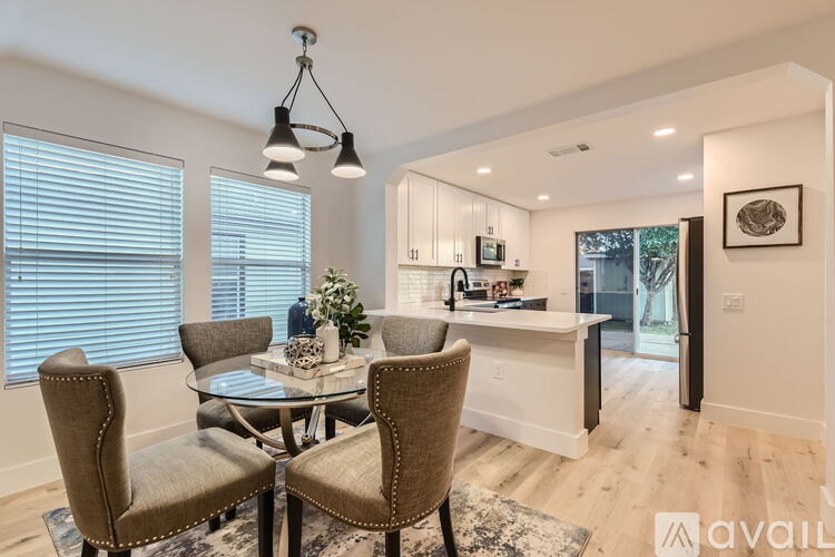 A dining room with a glass table and chairs.
