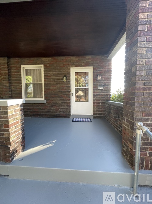 A white door is on the right side of a brick building.