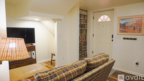 A living room with a couch, a lamp, and a painting on the wall.