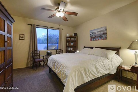 A bedroom with a bed, chair, and window.