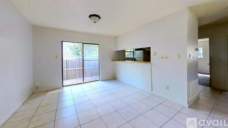 A spacious room with a sliding glass door leading to a backyard.