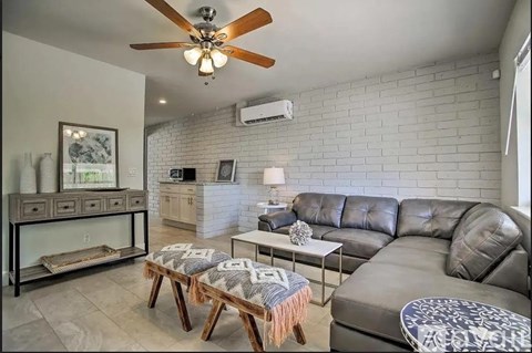 A living room with a grey sofa and a wooden bench.