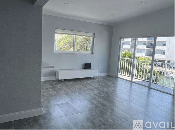 A spacious room with a bench and sliding glass doors.