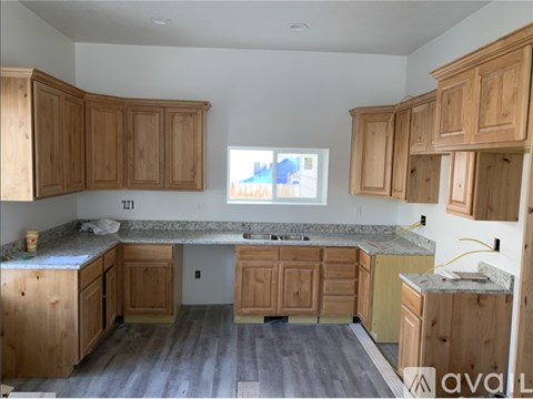 A kitchen with wooden cabinets and a marble countertop.