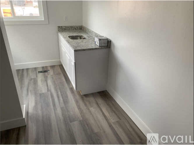 A kitchen with a granite countertop and a white cabinet.