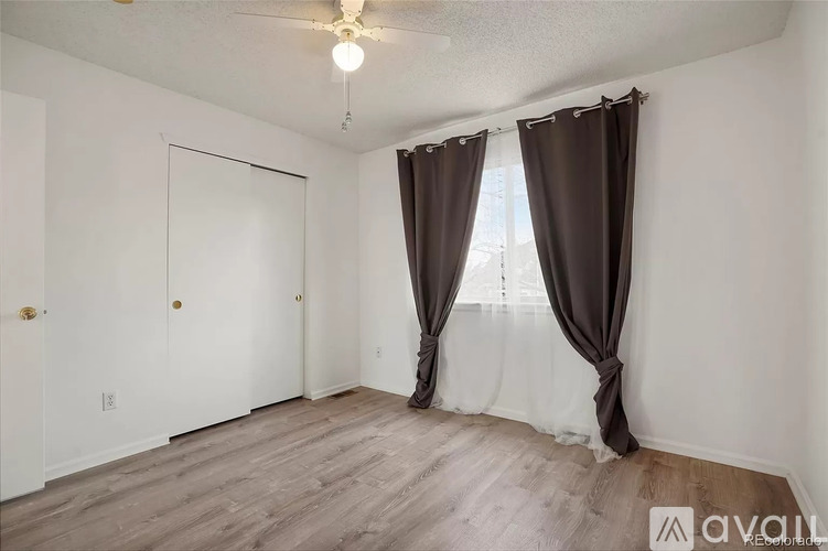 A room with a window covered by brown curtains.