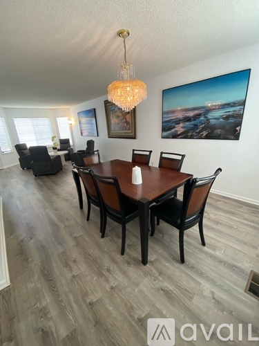 A dining room with a wooden table and chairs.