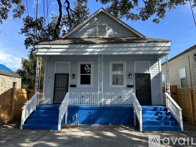A small white house with a blue staircase.