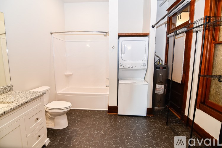A small bathroom with a toilet, sink, and a washer and dryer.