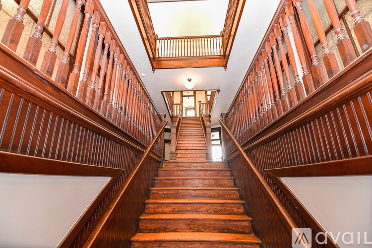 A wooden staircase with a skylight above it.