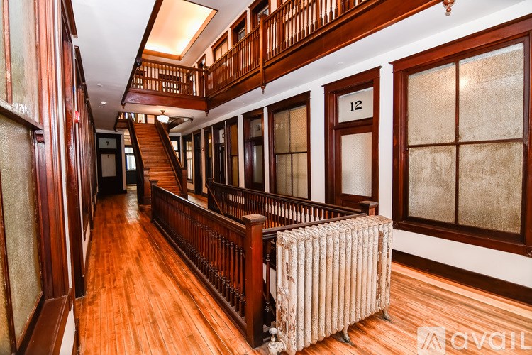 A wooden staircase with a metal railing and a radiator on the floor.