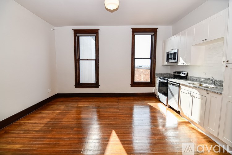 A kitchen with wooden floors and white walls.