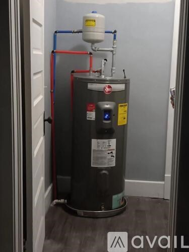 A water heater with a yellow caution label on it.