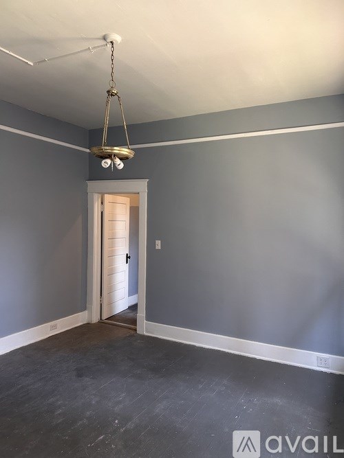 A room with a grey wall and a white door.