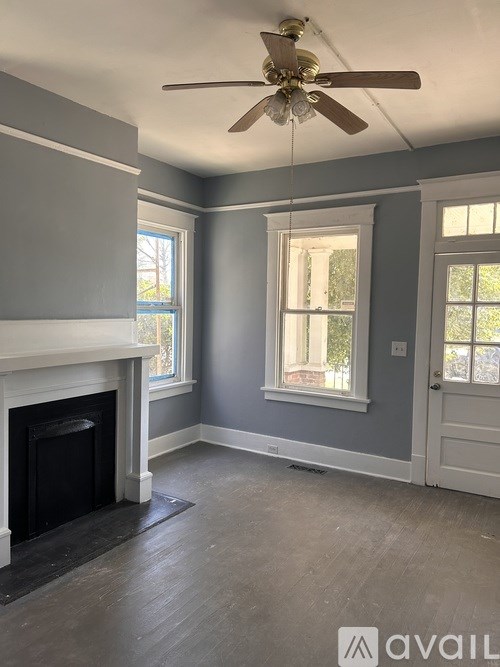A room with a fireplace and a ceiling fan.