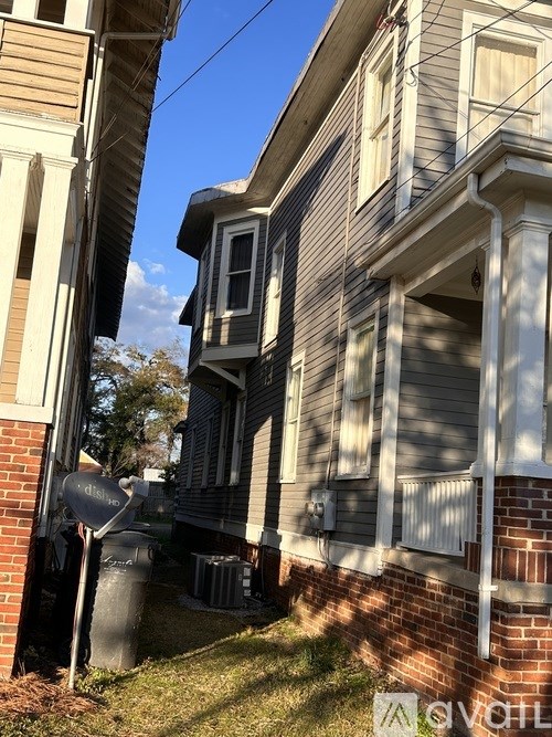 A grey house with a satellite dish on the left.