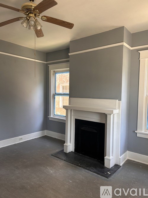 A room with a fireplace and a ceiling fan.