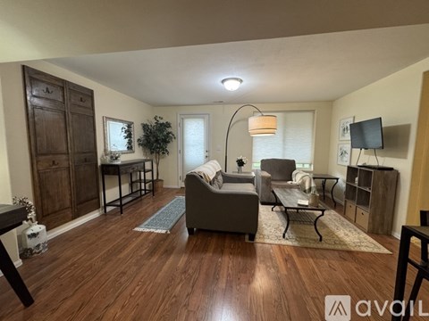 A living room with a grey couch and a wooden cabinet.