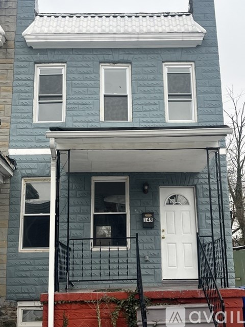 A blue house with a white door and windows.