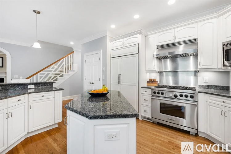 A kitchen with white cabinets and a granite countertop.