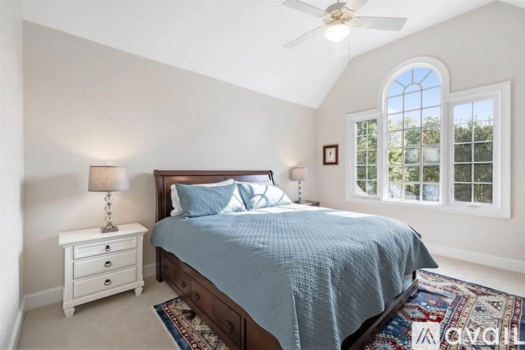 A bedroom with a bed, nightstand, and window.