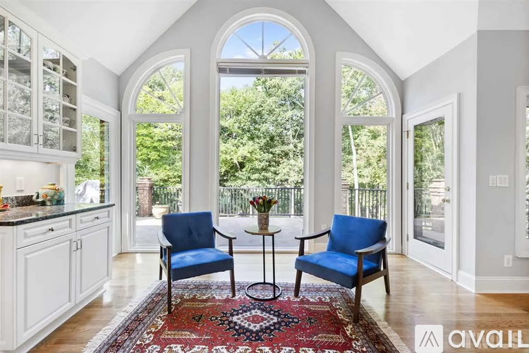 A living room with two blue chairs and a round table in the middle.
