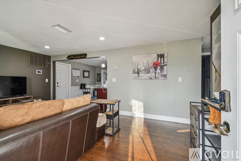 A living room with a brown couch and a coffee table.