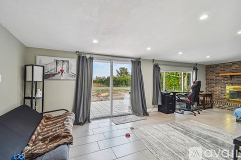 A living room with a couch, a chair, a table, and a window with curtains.