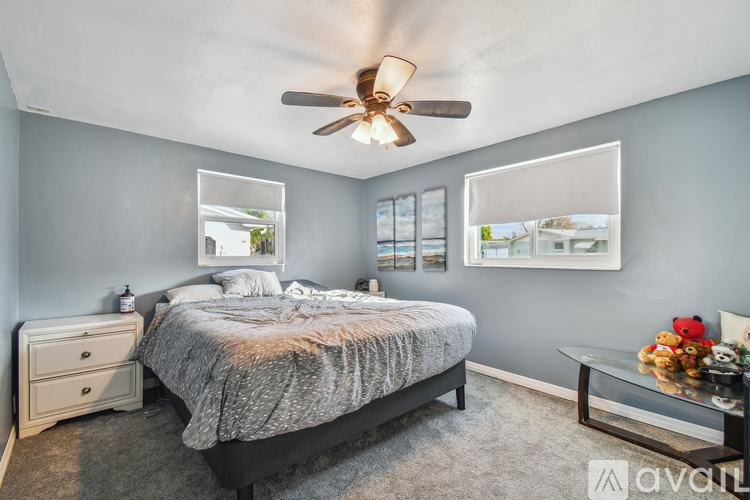 A bedroom with a bed, dresser, and ceiling fan.