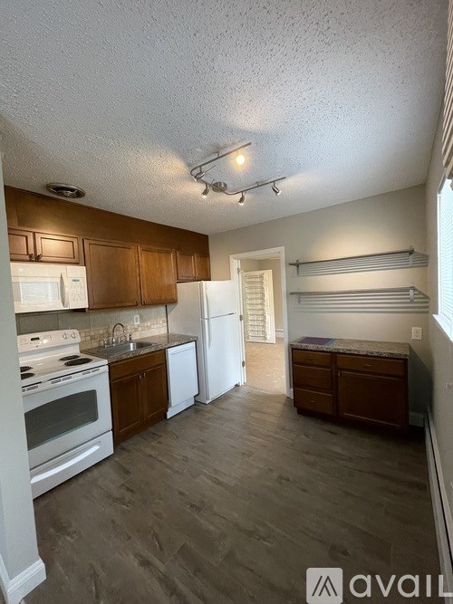 A kitchen with wooden cabinets and a white refrigerator.