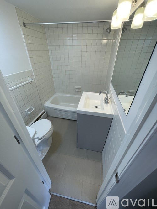 A white bathroom with a toilet, sink, and bathtub.