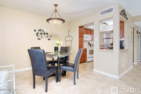 A dining room with a table and chairs.