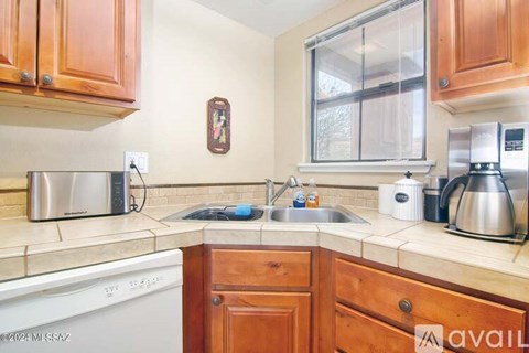 A kitchen with wooden cabinets and a white dishwasher.