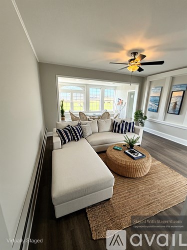 A living room with a white couch and a ceiling fan.