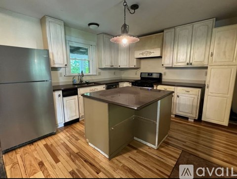 A kitchen with wooden floors and a large island in the middle.