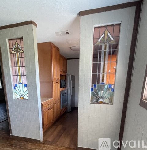 A kitchen with wooden cabinets and stained glass windows.