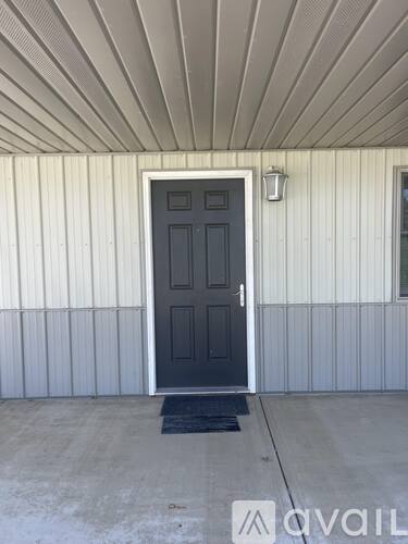A black door is on the right side of a white wall.
