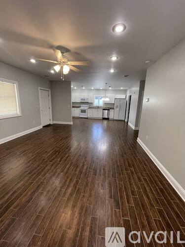 A room with wooden flooring and a ceiling fan.