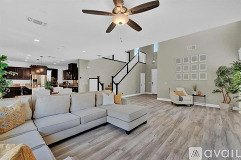 A living room with a white couch and a ceiling fan.