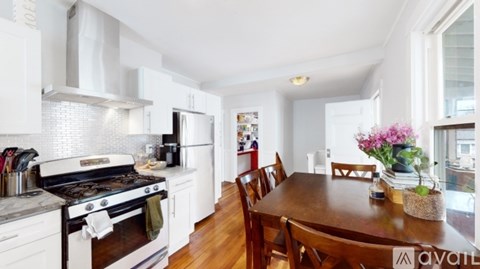 A kitchen with white cabinets and a wooden table.