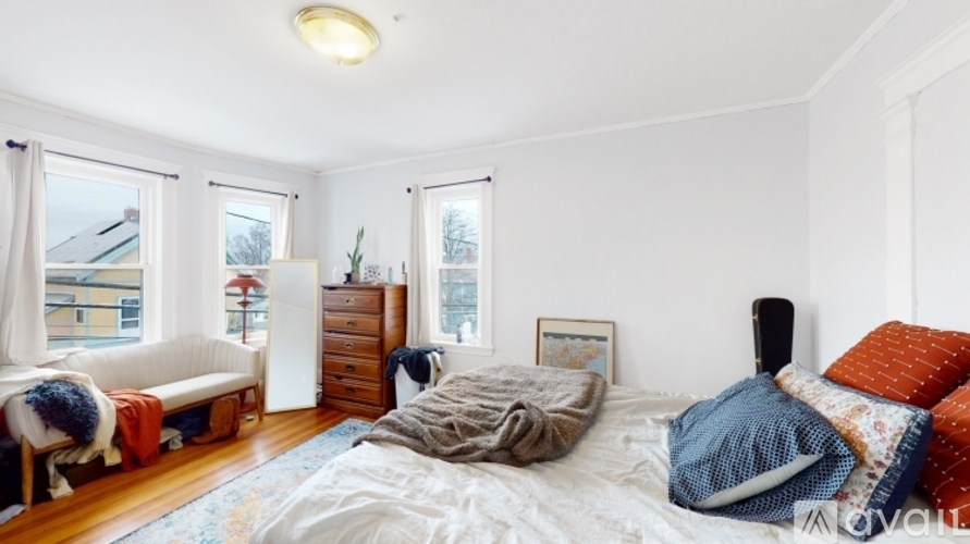 A bedroom with a bed, dresser, and window.