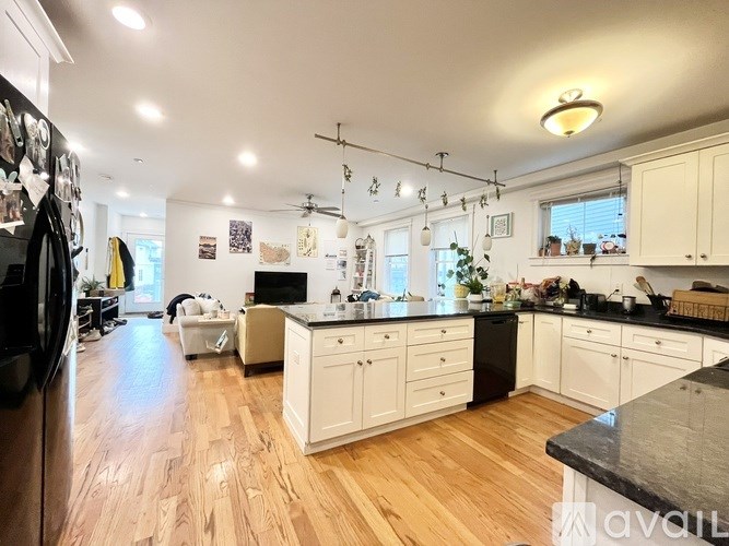 A kitchen with wooden floors and white cabinets.