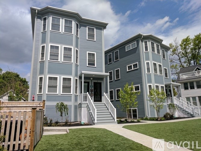 A two-story house with a front porch and a fence.