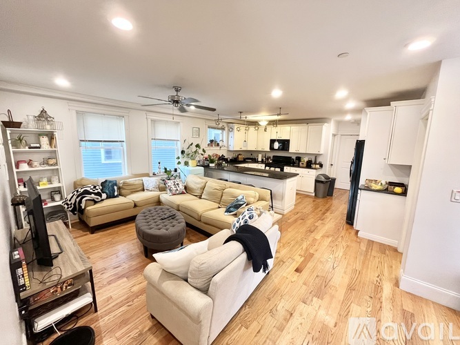 A living room with a white couch and a wooden floor.