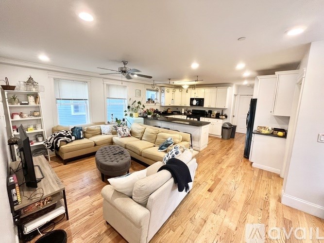 A living room with a white couch and a wooden floor.