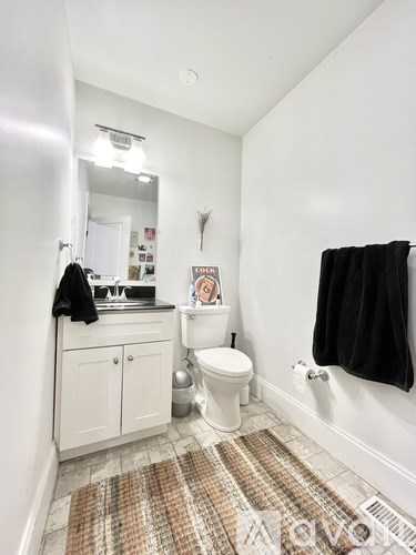 A bathroom with a toilet, sink, and mirror.
